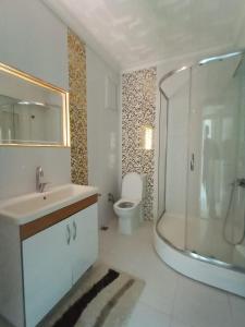 a bathroom with a sink and a shower and a toilet at Site içerisinde deniz manzaralı ve sahile yakın otopark sorunu bulunmayan kiralık daire in Fatsa