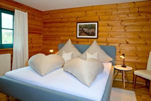 a bedroom with a bed with two heart shaped pillows at Ferienhaus Mitterdorf in Mitterfirmiansreut