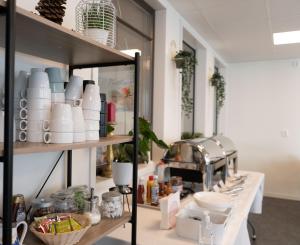 a kitchen with a shelf with dishes on it at Hotell Stortorget, Östersund in Östersund