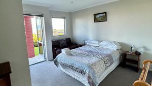 a bedroom with a bed and a sliding glass door at Pinnacle Apartment in Nelson