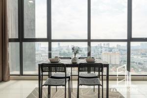 une table et des chaises devant une grande fenêtre dans l'établissement ATRIA SOFO Suites Petaling Jaya, Fantastic City-Wide View, Designed Suites, Spacious & Quiet Studio by Flexihome-MY, à Petaling Jaya