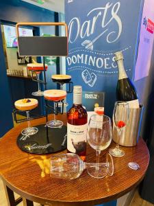 una mesa con botellas de vino y copas. en Letting Rooms @ Charles Dickens, en Wigan