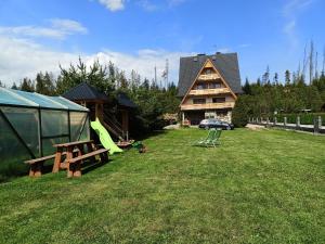 un gran patio con una casa y una mesa de picnic en Żegleniówka, en Małe Ciche