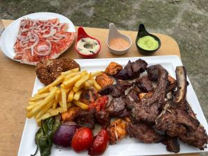 a plate of food with meat and french fries at Dream Nest Resorts in Skardu