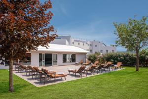 grupa krzeseł i stołów na patio w obiekcie Golden Tulip Dieppe Hôtel & Spa w mieście Saint-Aubin-sur-Scie