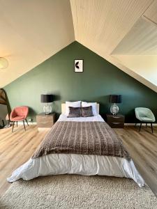 a bedroom with a large bed with a green wall at Chez Maurice - Stylish French Country House in Cherrueix