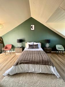 sypialnia z dużym łóżkiem i zieloną ścianą w obiekcie Chez Maurice - Stylish French Country House w mieście Cherrueix