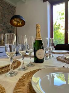 a bottle of wine sitting on a table with wine glasses at Chez Maurice - Stylish French Country House in Cherrueix