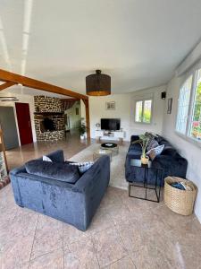 a living room with two couches and a fireplace at Chez Maurice - Stylish French Country House in Cherrueix