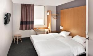 ein Hotelzimmer mit 2 Betten und einem Fenster in der Unterkunft B&B HOTEL Wrocław Centrum in Breslau