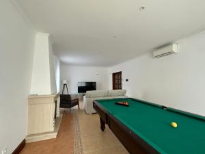 Una sala de estar con una mesa de billar y un sofá. en Quinta da Lu - Azorean Villa, en Ribeira Grande