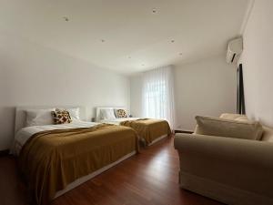 Una habitación blanca con dos camas y un sofá. en Quinta da Lu - Azorean Villa, en Ribeira Grande 11 fotos más