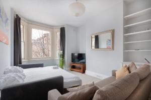 - un salon avec un lit et un canapé dans l'établissement 1 bed Clapham Junction apartment, à Londres