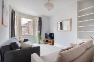 a living room with two couches and a tv at 1 bed Clapham Junction apartment in London