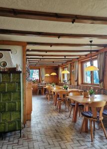 a restaurant with wooden tables and chairs and windows at Almgasthaus Glocknerblick in Großkirchheim