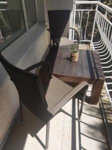 2 stoelen en een houten tafel op een balkon bij Хотел Ескана in Shkorpilovtsi