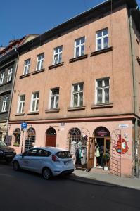 biały samochód zaparkowany przed ceglanym budynkiem w obiekcie Krakowsky Apartment w Krakowie