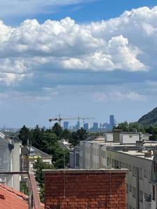 a view of a city with buildings and clouds at Rooftop - Vienna View in Klosterneuburg