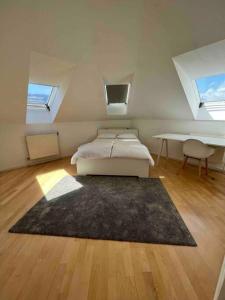 a bedroom with a bed and a desk in a attic at Rooftop - Vienna View in Klosterneuburg