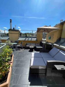 a patio with tables and chairs and an umbrella at Rooftop - Vienna View in Klosterneuburg