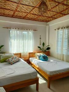 een slaapkamer met 2 bedden en een raam bij Sea Me in Kansaloay