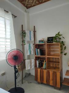 KansaloayにあるSea Meの扇風機と本棚付きの部屋