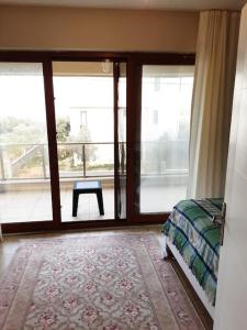 1 dormitorio con cama y vistas a un balcón en ERDEK, en Erdek