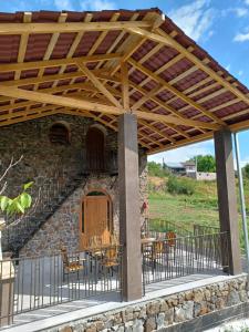 a wooden pergola over a patio with tables and chairs at Guest House Climbing 