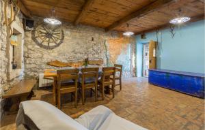 uma sala de jantar com mesa e cadeiras e uma parede de pedra em Nice Home In Gora Glusic With House Sea View em Stanišovi