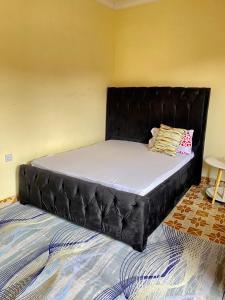a bed with a black headboard in a room at Happy home in Arusha