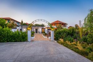 a driveway leading to a house with an arch at Villa Marilena in Corfu Town