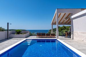 a swimming pool in front of a house at Villa Blue Panorama in Vela Luka