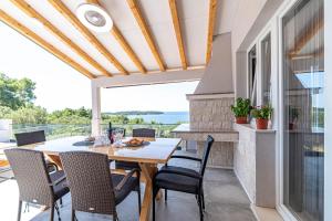 Villa Blue Panorama في فيلا لوكا: غرفة طعام مع طاولة وكراسي على شرفة
