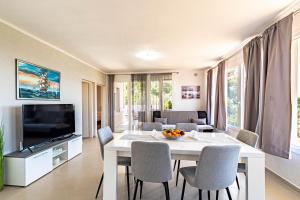 - un salon avec une table et des chaises blanches dans l'établissement Villa Blue Panorama, à Vela Luka