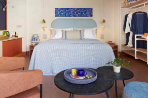 um quarto com uma cama com uma bandeja de comida numa mesa em LOOM ATHENS em Atenas