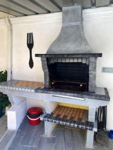 a outdoor fireplace with a fork on the wall at 2 bedrooms house with enclosed garden and wifi at Ponte de Vagos in Ponte de Vagos
