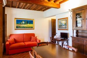 een woonkamer met een rode bank en een tafel bij Casa Vacanza Il Carpignone 7 in Massa Marittima