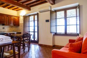 een keuken en een woonkamer met een tafel en stoelen bij Casa Vacanza Il Carpignone 7 in Massa Marittima