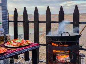 a grill with a plate of vegetables and a plate of food at Wadi Al-Wala View Camp in Madaba