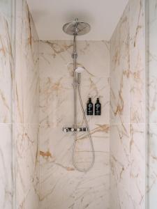 パリにあるSolly Hôtel Parisの白い大理石のバスルーム(シャワー付)