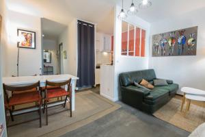 a living room with a green couch and a table at Studio Tarbes Marcadieu in Tarbes