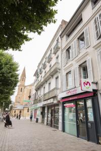 una strada con edifici e persone che camminano su un marciapiede di Studio Tarbes Marcadieu a Tarbes