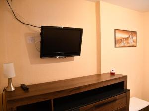 uma televisão de ecrã plano pendurada numa parede em B&M Apartment em Zierenberg