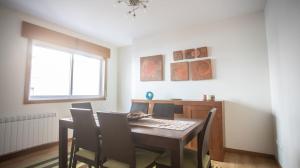 a dining room with a table and chairs and a window at Apartamento nuevo al lado de la playa en A Guarda in A Guarda