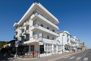 ein großes weißes Gebäude an der Straßenseite in der Unterkunft Hotel Lungomare in Bellaria-Igea Marina