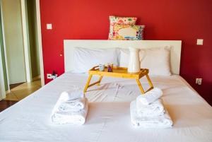 Un dormitorio con una cama blanca y una mesa. en Spacious and Modern Apt in the Suburbs of Athens en Atenas