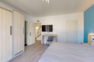 Schlafzimmer mit einem großen weißen Bett und einem Schreibtisch in der Unterkunft 10.Studio#Creteil#Loft#Cinéma in Créteil