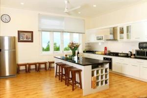 a large kitchen with a counter and chairs in it at Sealinks city - Tvila in Phan Thiet