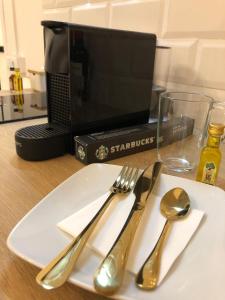um prato branco com um garfo e uma colher numa mesa em Siboni Luxury Rooms - Adults Only em Tortosa