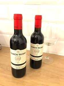 dos botellas de vino sentadas en una mesa con una copa en Siboni Luxury Rooms - Adults Only, en Tortosa